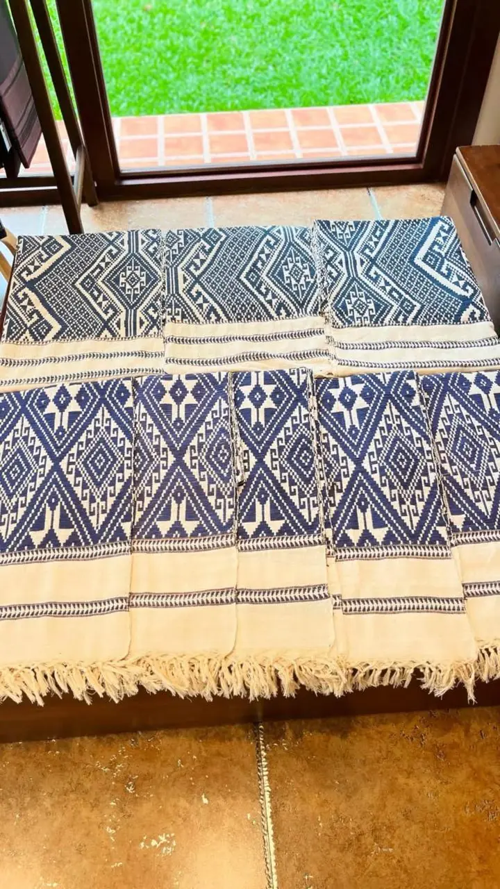 Mehrere handgewebte Schals in Indigo und Naturweiss mit Rautenmustern und Fransen, nebeneinander ausgelegt
